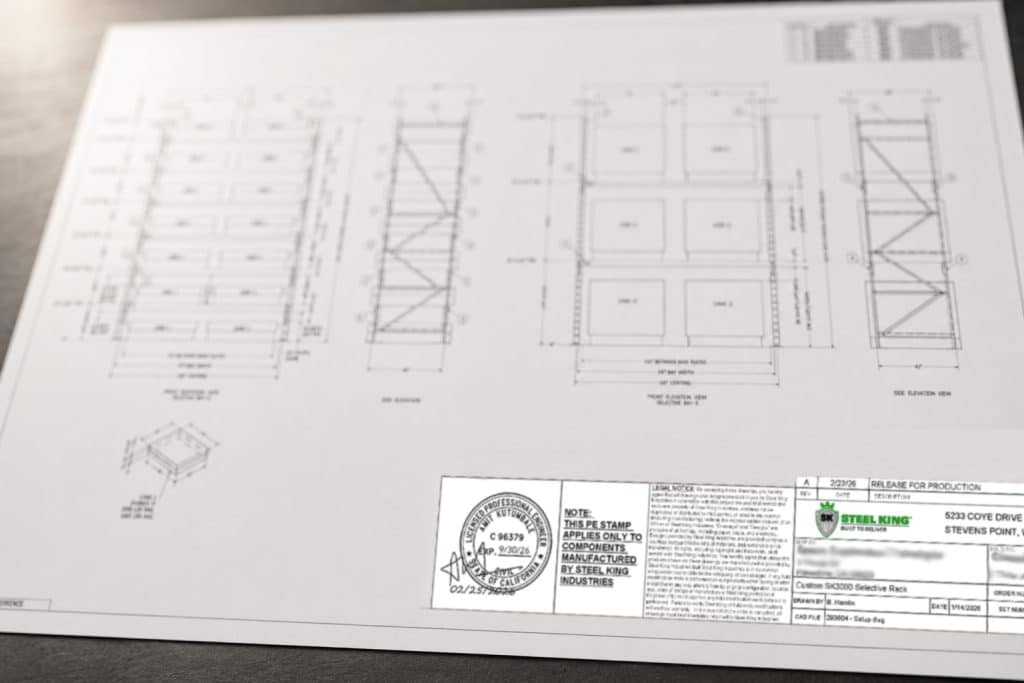 Technical blueprint on a white desk showing floor plans, elevations, and stamped notes/N. piece of engineering drawing.